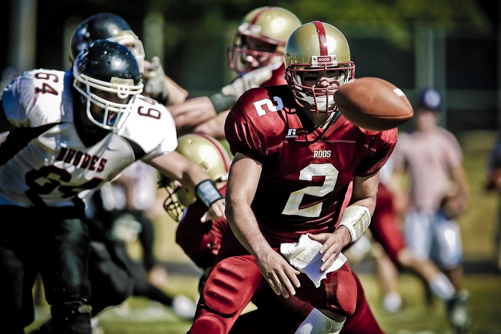 A quarterback takes the snap in a college football game